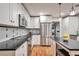 Modern kitchen with white cabinets, dark countertops, stainless steel appliances, and hardwood floors at 503 Lois Dr, Louisville, CO 80027
