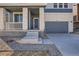 Two-story home with gray and white brick exterior, attached garage, and small front porch at 783 Sunflower Dr, Brighton, CO 80601