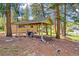 A large carport and covered area highlight the backyard of this home, surrounded by mature shade trees at 26351 Sheldon St, Kittredge, CO 80457
