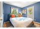 Comfortable primary bedroom features nice light, blue walls, and backyard views at 26351 Sheldon St, Kittredge, CO 80457