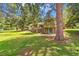 Charming home exterior with a large lawn, mature trees, and a stone foundation, nestled in a serene setting at 26351 Sheldon St, Kittredge, CO 80457