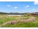 Picturesque lake view with mountain backdrops, blending natural beauty with the rustic charm of surrounding buildings at 26351 Sheldon St, Kittredge, CO 80457