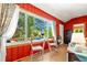 Bright sun room with colorful curtains and view to outside deck with chairs and umbrella at 26351 Sheldon St, Kittredge, CO 80457