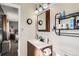 Bathroom featuring a vanity, a framed mirror with lighting, and a storage rack at 15373 Uravan St, Brighton, CO 80601