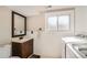Convenient laundry room featuring a sink, vanity, and a window next to the white washer and dryer at 15373 Uravan St, Brighton, CO 80601