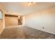 Cozy living room featuring neutral paint, plush carpeting, and stairs leading to the upper level of the home at 15373 Uravan St, Brighton, CO 80601