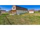 Outbuilding on green grass with red trim, barn roof, small covered porch, and two additional outbuildings at 15373 Uravan St, Brighton, CO 80601