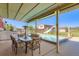 Outdoor patio featuring a swimming pool with a water slide, covered seating, and a fenced yard at 15373 Uravan St, Brighton, CO 80601