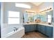 Bright bathroom featuring double sinks, soaking tub and wood-look flooring at 4520 S Jebel Ct, Aurora, CO 80015