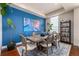 Dining room featuring modern art on the blue accent wall and a wood table at 1488 Madison St # 307, Denver, CO 80206