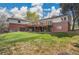Home's backyard featuring a grassy lawn, wooden deck and patio, with chain-link fencing and mature trees at 4095 Field Dr, Wheat Ridge, CO 80033