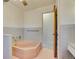 Retro bathroom features a pink bathtub, tile, and opens to another room at 4095 Field Dr, Wheat Ridge, CO 80033