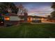 Charming home with a brick facade, well-manicured lawn, and attached garage under a colorful twilight sky at 4095 Field Dr, Wheat Ridge, CO 80033