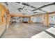 Spacious garage with exposed ceiling beams, concrete floor, and attached workshop space at 4095 Field Dr, Wheat Ridge, CO 80033