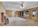 Living room with wood paneled walls, fireplace, large windows, and ceiling fans at 4095 Field Dr, Wheat Ridge, CO 80033
