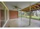 Covered patio with brick siding, large windows, ceiling fan and views of the lush backyard at 4095 Field Dr, Wheat Ridge, CO 80033