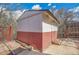 Exterior view of a two-tone storage shed with double doors in backyard at 4095 Field Dr, Wheat Ridge, CO 80033