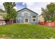 Spacious backyard featuring a lush lawn, privacy fence, and mature trees at 10364 Ravenswood Way, Highlands Ranch, CO 80130