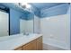 A full bathroom with a tub, shower, and vanity with mirror in blue color scheme at 10364 Ravenswood Way, Highlands Ranch, CO 80130
