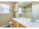 A well-lit bathroom with a double vanity, and a shower with decorative tile accents at 10364 Ravenswood Way, Highlands Ranch, CO 80130