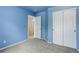 Blue bedroom featuring a closet, carpet, and an open doorway leading to another room at 10364 Ravenswood Way, Highlands Ranch, CO 80130