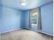 Blue bedroom featuring a window with curtains, light fixture, and neutral carpet at 10364 Ravenswood Way, Highlands Ranch, CO 80130