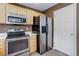 Kitchen with stainless steel range, microwave, and refrigerator near white door at 10364 Ravenswood Way, Highlands Ranch, CO 80130