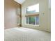 Bright living room featuring high ceilings, large windows, and neutral carpet at 10364 Ravenswood Way, Highlands Ranch, CO 80130