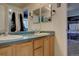 Bathroom with dual sinks, wooden cabinets, and decorative wall art at 43400 Somerset Ct, Elizabeth, CO 80107