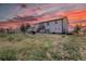 Back exterior of a two-story home with black trim and red sunset sky at 43400 Somerset Ct, Elizabeth, CO 80107