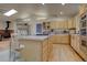 Bright kitchen featuring wood cabinets, island with cooktop, and cozy eating area with wood stove at 43400 Somerset Ct, Elizabeth, CO 80107