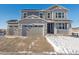 Two-story house with gray siding, three-car garage, and snowy driveway at 24520 E 36Th Ave, Aurora, CO 80019