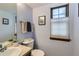 Powder room features a neutral paint, framed window, and decorative fixtures at 8155 Everett E St, Arvada, CO 80005