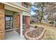 Charming front porch seating area with brick accents and a view of the landscaped front yard at 8155 Everett E St, Arvada, CO 80005