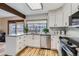 Updated kitchen features white cabinets, stainless steel appliances, and a bright window view at 8155 Everett E St, Arvada, CO 80005