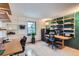 Bright office space with custom shelving, dual desks, and a large window for ample natural light at 8155 Everett E St, Arvada, CO 80005