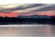 View of partially frozen pond with a mountain view at dusk at 8155 Everett E St, Arvada, CO 80005