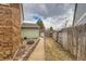 Side yard with brick pathway and shed, highlighting the property's functional outdoor space at 8155 Everett E St, Arvada, CO 80005