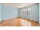 Light-filled bedroom featuring hardwood floors and a large window at 17624 E Peakview Ave, Aurora, CO 80016