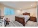 Basement bedroom with a wooden bed frame and a cozy armchair at 17624 E Peakview Ave, Aurora, CO 80016