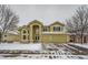 Two-story house with a large front yard, two car garage, and snow covered driveway at 17624 E Peakview Ave, Aurora, CO 80016