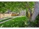Expansive fenced backyard featuring a well-maintained lawn, mature trees providing shade, and a stone pathway leading to the house at 351 Bannock St, Denver, CO 80223
