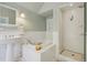 Well-lit bathroom with wainscoting, pedestal sink, tub, and separate shower at 351 Bannock St, Denver, CO 80223