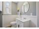 Well-lit bathroom featuring wainscoting, modern sink vanity and round mirror at 351 Bannock St, Denver, CO 80223