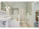 Bathroom featuring a pedestal sink, soaking tub, glass shower, and decorative tile floor at 351 Bannock St, Denver, CO 80223