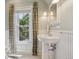Light-filled bathroom with pedestal sink, window, and wainscoting at 351 Bannock St, Denver, CO 80223