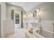 Bright bathroom with double sinks, wainscoting, a soaking tub, and a window at 351 Bannock St, Denver, CO 80223