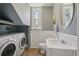 Cozy bathroom with modern fixtures, wainscoting, and a combined laundry setup at 351 Bannock St, Denver, CO 80223