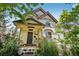 Charming home featuring a brick facade, a covered porch, a manicured garden, and a new dark wood front door at 351 Bannock St, Denver, CO 80223