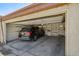 A black Acura MDX parked inside an open garage with white brick walls, a concrete floor and an auto door opener at 351 Bannock St, Denver, CO 80223